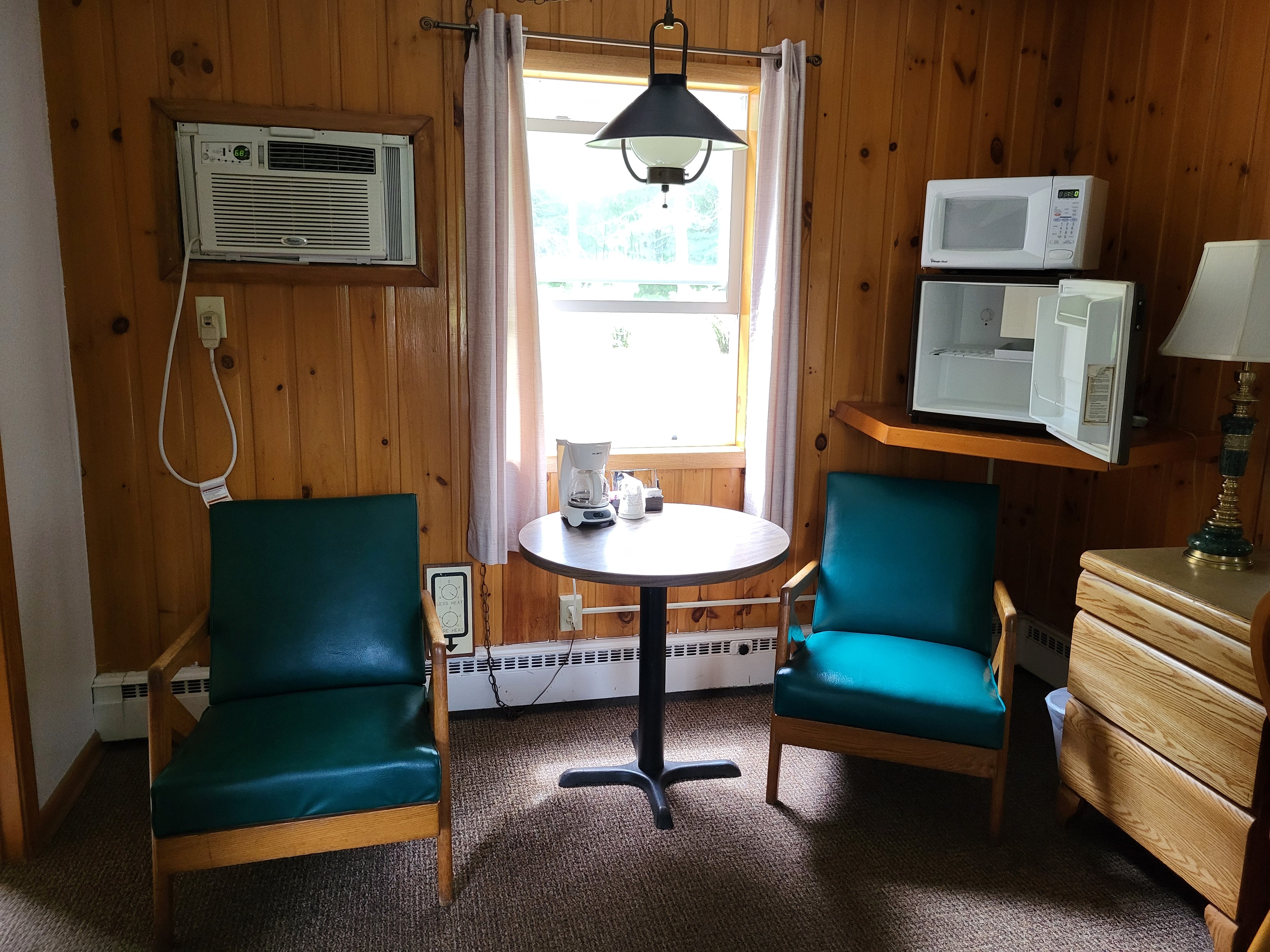 Cabin room with wood paneling and teal chairs